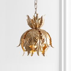 a gold colored chandelier hanging from a white door with the light shining on it