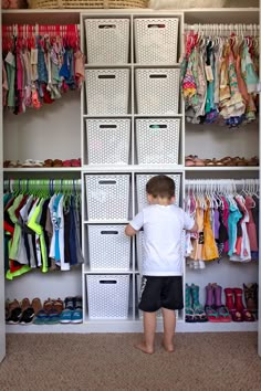 a young boy standing in front of a closet full of clothes and shoes, with his hands on the drawers