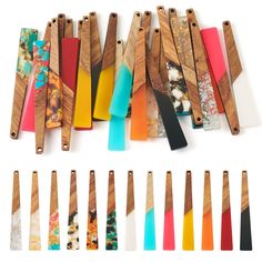 several different types of wooden utensils lined up on a white surface with colorful handles