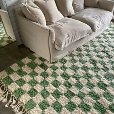 a couch sitting on top of a green and white rug