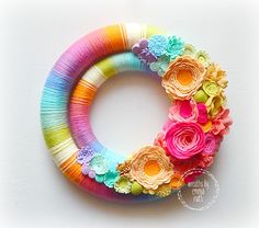 a colorful wreath made out of yarn and paper flowers