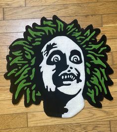 a close up of a rug on a floor with a person's face painted on it