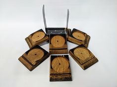 six wooden coasters with knives stuck in them