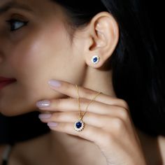 a close up of a person wearing a necklace and ring with blue stones on it