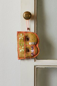 a door handle with an orange and pink patchwork design hanging from it's side