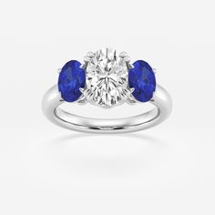 three stone engagement ring with blue sapphire stones on the sides and an oval diamond in the center