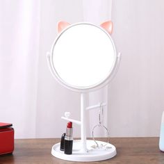 a mirror that is sitting on top of a table with lipstick in front of it