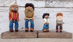 four small figurines are standing on wooden planks