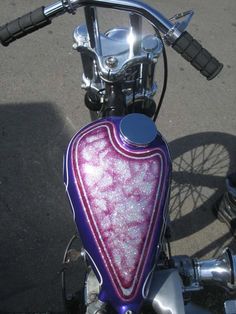 a close up of a motorcycle handlebar with a pink and purple design on it