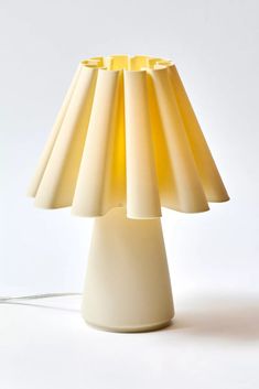 a white table lamp with a yellow shade on it