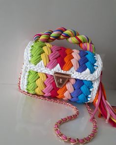 a multicolored handbag on a white surface