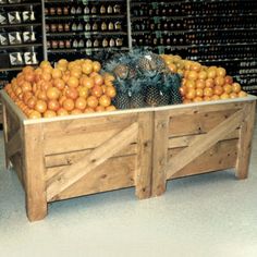 an old wooden crate filled with oranges and other fruit in a grocery store's produce section