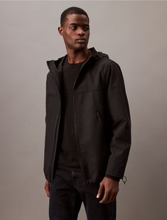 Accentuated with seaming details at the upper chest, this jacket is a lightweight layer for cooler weather. Made with a stand collar and a drawstring hood. Designed with a zip closure at the front and slip pockets at the sides.  Material: 92% Polyester, 8% Elastane. Black Nylon Utility Outerwear, Urban Utility Jacket With Double-lined Hood, Black Utility Outerwear With Double-lined Hood, Utility Nylon Hooded Jacket With Double-lined Hood, Luxury Men's Single-breasted Utility Jacket, Utility Jacket, Stand Collar, Calvin Klein