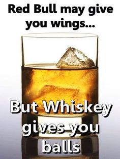 a glass filled with ice sitting on top of a table next to a sign that says, red bull may give you wings but whiskey gives you balls