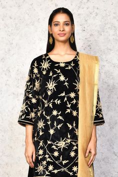 Black kurta with contrast floral embroidery. Paired with a lehenga, highlighted with floral embroidered hem. Comes along with a dupatta.
Components: 3
Pattern: Embroidery
Type Of Work: Floral
Neckline: Round Neck
Sleeve Type: Three Quarter Sleeves
Fabric: Kurta and Lehenga: Velvet, Dupatta: Chanderi, Lining: Shantoon
Color: Black
Other Details: 
Length:
Kurta: 36 inches
Lehenga: 40 inches
Occasion: Mehendi and Haldi - Aza Fashions Festive Anarkali Top With Sheer Dupatta, Traditional Festive Tops With Sheer Dupatta, Traditional Tops With Dupatta For Festive Occasions, Traditional Festive Tops With Dupatta, Traditional Tops With Dupatta For Diwali, Festive Designer Wear Tops With Dupatta, Festive Designer Top With Dupatta, Navratri Blouse Piece With Dupatta, Black Palazzo Set With Gota Work