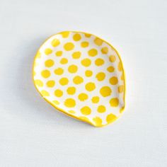 a yellow and white polka dot dish sitting on top of a table