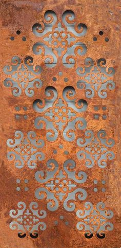 an old rusty metal plate with blue and silver designs on the outside, as well as holes in the middle