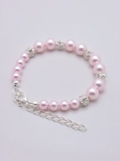 LISTING IS FOR ALL 5 LIGHT PINK PEARL BRACELETS This set of 5 bracelets is hand-crafted using light pink Swarovski pearls and silver plated rhinestones. Approximately 6 1/2 inches at shortest length with silver plated extension chain for an adjustable fit up to 8 inches. Each comes in a gift box, perfect for gift-giving! Standard fits sizes between 6.5-8 inches. Pearl available in white, ivory, light pink, light grey and dark grey - just add note at checkout (standard is light pink). SHIPPING: T Light Pink Bracelet, Pink Pearl Bracelet For Wedding, Light Pink Accessories, Pink Charm Bracelet With Round Beads For Parties, Adjustable Pink Crystal Bracelet For Wedding, Elegant Pink Charm Bracelet With Round Beads, Pink Elegant Charm Bracelet, Pink Pearl Bracelet With Round Beads For Formal Occasions, Pink Beaded Pearl Bracelet For Wedding