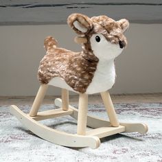 a wooden rocking toy with a brown and white deer on it's back legs