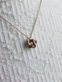 "Simple Geometric Knot Chain Pendant Necklace Chain Length: 30″  Chain Width: 1 mm Clasp: Yes Type of Clasp: Lobster Claw Pendant Length: 1/2\" Pendant Width: 1/2\" Weight: 6g Metal: Rhodium or gold plated chain, brush metal pendant, tarnish resistant, brass Options: Silver Gold Champagne (Rose Gold) Gunmetal" Rose Gold Metal Jewelry With Chain, Rose Gold Link Necklace With Clavicle Chain, Rose Gold Link Necklace For Anniversary, Rose Gold Link Necklace, Rose Gold Metal Necklaces For Anniversary, Rose Gold Metal Necklace For Anniversary, Rose Gold Pendant Necklace With Box Chain, Rose Gold Box Chain Necklace As Gift, Rose Gold Box Chain Necklace Gift