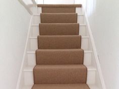 a carpeted staircase leading up to the top floor in a home with white walls