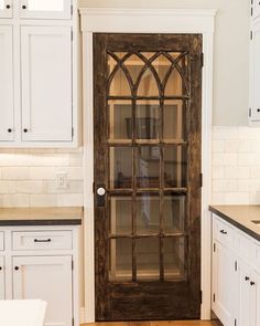 an open glass door in a kitchen with white cabinets