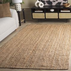 a living room with a couch, coffee table and rugs on the floor in front of a television