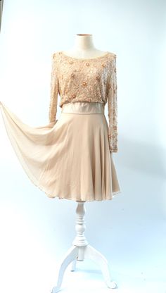 "Coolest dress...could be a wedding dress...or a guest of.. In a peach ivory with beautiful silkabsolutely stunning!! Excellent Beaded on tulle lined in silk Measuring: 36\" length Bust: 36\" Waist: 26\" Hip: 36\" + Sleeves: 22\" Pet Free/smoke free Enjoy!" Elegant Cream Dress With Sheer Bodice, Cream Dress With Sheer Bodice For Evening, Elegant Apricot Chiffon Dress, Elegant Embellished Chiffon Mother Of The Bride Dress, Fitted Silk Chiffon Dress For Wedding Guest, Cream Evening Dress For Wedding Guest, Champagne Silk Evening Dress For Wedding, Elegant Apricot Evening Dress, Sheer Silk Chiffon Wedding Dress