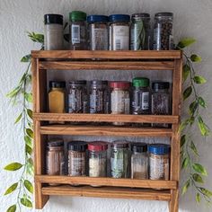 a wooden shelf with spices and herbs on it