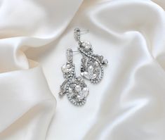 Accentuate your bridal ensemble with our exquisite LISA earrings. Handcrafted to order with Austrian crystals and pearls, these rhodium plated earrings exude luxury and sophistication. The delicate silver floral design adorned with white opal crystals will add a touch of elegance to your special day. - Handcrafted in my PA studio- Clear and white opal Austrian crystals and pearls- Rhodium (silver) plated- Earrings measure 2.5 inches x 1.25 inch- Handcrafted in the US.- Nickel free and hypoallerg Elegant Silver Crystal Earrings, Elegant Silver Chandelier Earrings With Sparkling Stones, Exquisite Silver Bridal Earrings, Elegant Silver Crystal Earrings With Rhinestones, Elegant Sparkling White Gold Crystal Earrings, Elegant Diamond White Crystal Earrings With Rhinestones, Elegant White Gold Crystal Earrings With Sparkling Stones, Elegant Crystal Earrings With Sparkling Stones For Wedding, Exquisite Silver Bridal Earrings With Diamond Accents