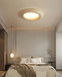 a bedroom with a bed, nightstands and lights on the wall above it is lit by a round light fixture