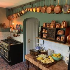 a kitchen with pots and pans hanging from the ceiling, along with other cooking utensils