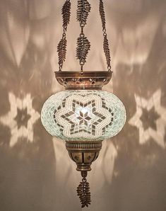 a hanging light fixture with an intricate design on it