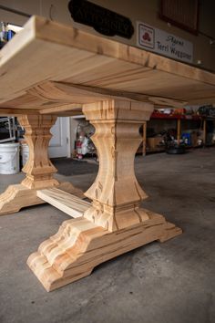 a wooden table sitting in a garage next to other woodworking supplies and tools on the floor