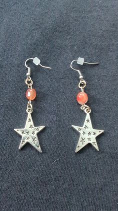 Earrings with red carnelian beads and silver star charms Red Star-shaped Beaded Jewelry, Nickel-free Red Carnelian Earrings, Silver Star-shaped Beaded Earrings, Nickel-free Red Star Earrings, Red Star-shaped Nickel-free Earrings, Red Star Charm Earrings, Red Star-shaped Earrings With Star Charm, Red Star Charm Earrings For Gift, Red Carnelian