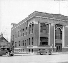 an old building with cars parked in front of it