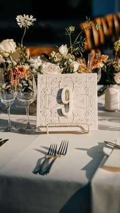 the table is set with silverware and white napkins, which are decorated with flowers