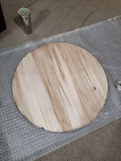 a round wooden board sitting on top of a piece of duct taped to the floor