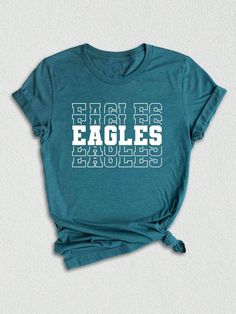 Introducing our Team Mascot Shirt, a must-have for all proud Eagles!  Show off your team spirit and pride with this Eagles School Shirt, designed to celebrate your love for the Eagles and their glorious mascot. This Eagles Mascot Tee is perfect for game days, pep rallies, or simply to represent your team wherever you go. Crafted with premium quality materials, this Eagles Pride Shirt ensures comfort and durability. The soft fabric keeps you feeling cozy, while the vibrant design showcases your l Eagles School Shirt, College Sports Season Fan Apparel Tops, Team Spirit T-shirt With Team Name For College, Game Day Crew Neck Top With Team Name, Fan Apparel Tops With Team Name For Sports Season, Team-colored Graphic Tee For Game Day, Game Day Football Season Tops With Logo Print, Graphic Tee Tops In Team Colors For Game Day, Sports Season Fan Gear Tops With Team Name