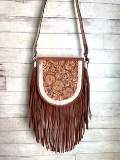 9" H  x 10" W  x 5" D Western style bag with cowhide and leather adorned with leather fringe  Flap snaps closed and has zipper closure at top zipper and open pocket inside  tooled leather strap - 48" crossbody (removable Select cowhide pattern option from drop down menu. Cowhide and leather colors vary.  Select exact item from drop down.    Not customizable - handmade by American Darling Products Brown Western Bag With Fringe, Western Brown Bag With Fringe, Western Leather Bag With Fringe, Western Style Saddle Bags For Everyday Use, Western Saddle Bag For Everyday Use, Western Style Fringed Bags For Everyday Use, Western Style Bags With Fringe For Everyday Use, Western Style Fringe Bags For Everyday Use, Western Style Leather Crossbody Bag