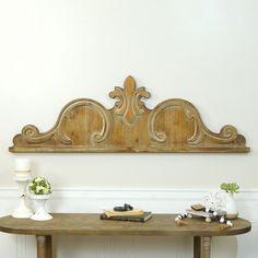 a wooden table with two vases on top of it and a shelf above it