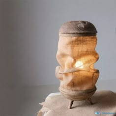 a light that is sitting on top of a cloth covered tablecloth with an object in the shape of a human head