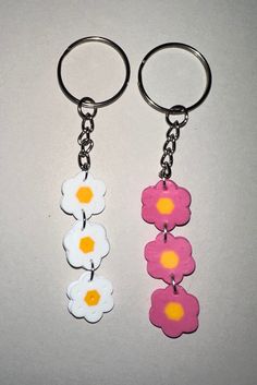 two key chains with flowers on them sitting next to each other