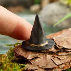 a tiny black hat sitting on top of a rock