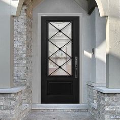 a black front door with an arched glass window on the side of a brick building