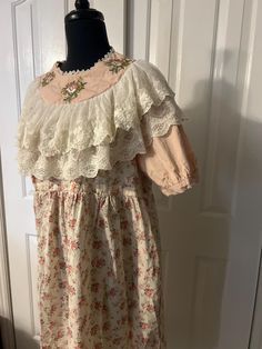 This is a gorgeous vintage Victorian/English farm style dress. Reminds me of Little House on the Prairie!  This dress is quite small and fit on a small size 1-3 mannequin Armpit to armpit 21" Collar 9" across  Top of shoulder to sleeve end 13" Sleeve diameter 12"  Length approx 44" It is in perfect condition Cottagecore Victorian Dress With Lace Trim For Garden Party, Vintage Short Sleeve Prairie Dress For Daywear, Vintage Prairie Dress With Short Sleeves For Daywear, Vintage Short Sleeve Prairie Dress With Floral Print, Vintage Floral Print Short Sleeve Prairie Dress, Vintage Long Sleeve Floral Embroidery Dress, Cotton Victorian Dress With Lace Trim In Cottagecore Style, Vintage Long Sleeve Dress With Floral Embroidery, Vintage Short Sleeve Dress With Lace Trim