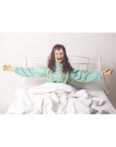 a creepy doll sitting on top of a bed