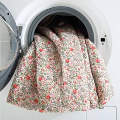 a flowered cloth is hanging from the front of a washing machine