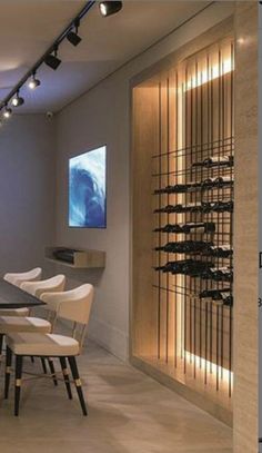 a dining room table and chairs with wine racks on the wall next to each other