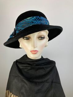 What a classic and classy black wool felt winter hat! This pretty black wool felt hat isn't a true fedora, but it has a similar feel but with a feminine spin. Instead of the top having a point at the front, it has a smooth oval crown. It's hand blocked over wooden hat blocks and hand sewn. The asymmetrical brim is also wider than a traditional fedora.  The band and bow are made with a black, teal and mint green fabric and then topped with a faceted black glass vintage button. This one simply never goes out of style. Handmade in the USA. In stock and ready to ship. One of a kind hat. FIT AND SIZE: Head size: 21 to 23 inches.  Inner adjustable grosgrain ribbon headband. Brim width 2 1/2 inches in the back left side, and 3 inches in the front and right side. HOW TO MEASURE YOUR HEAD SIZE: Pla Brimmed Felt Cloche Hat For Winter, Winter Felt Brimmed Cloche Hat, Formal Wool Hat Bands For Winter, Elegant Wool Felt Hat For Fall, Winter Felt Cloche Hat With Brim, Winter Formal Wool Hat Bands, Formal Wool Felt Hat For Winter, Formal Black Winter Top Hat, Wool Wide Brim Top Hat For Winter